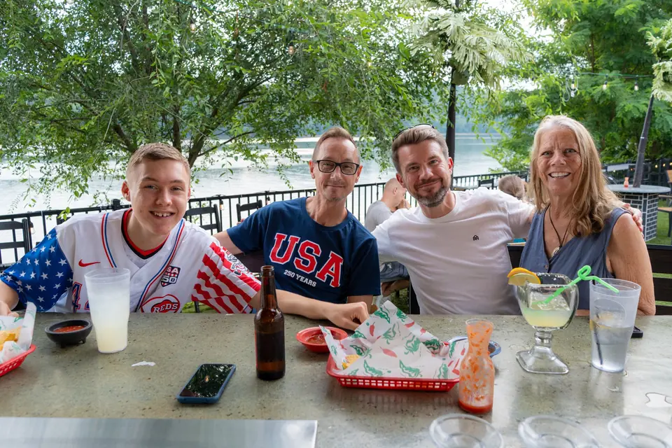 Friends at a terrace table with the Ohio River behind them