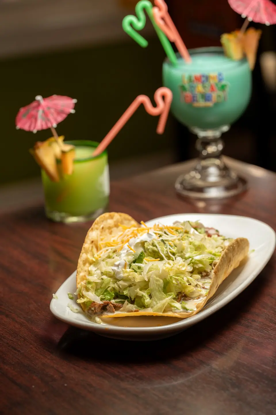 Taco salad with a fishbowl and a green drink