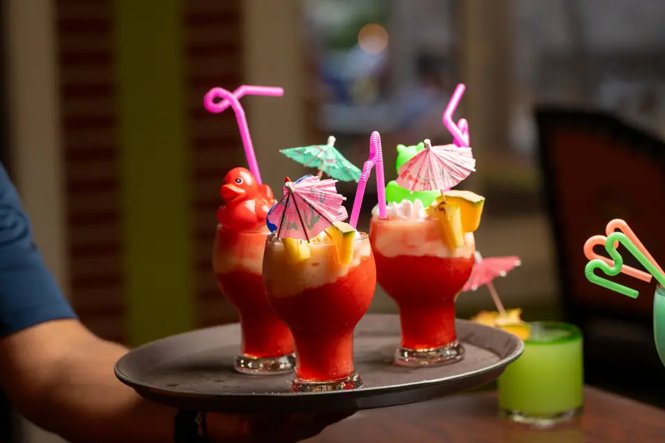 Server with a tray of fishbowl drinks